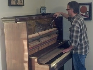 Chad Mitchell tuning an old upright piano